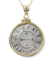 Up close shot of a 14k gold bezel setting with a genuine ancient Italian Medieval Grossi showing a large cross in the center. 
